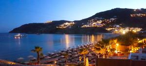 a view of a beach with umbrellas and the water at night at Sea Side Studios & Houses in Kalo Livadi