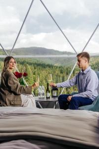 Rest&Ski Spa Resort في بوكوفِل: رجل وامرأة يجلسان على طاولة مع كؤوس للنبيذ