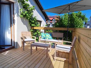a patio with two chairs and a table and an umbrella at Anka in Władysławowo