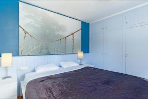 1 dormitorio con 1 cama y una pintura de un puente colgante en Villa Natalia C101, en Lloret de Mar