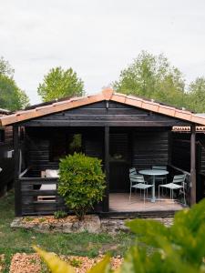a cabin with a table and chairs on a deck at wecamp Cudillero in El Pito