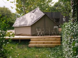 a green tent with chairs on a wooden deck at wecamp Cudillero in El Pito