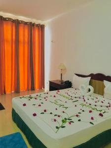 ein Schlafzimmer mit einem Bett mit Blumen darauf in der Unterkunft Hotel Dream Paradise in Ja-Ela