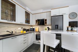een keuken met witte kasten en witte apparaten bij Leonardo50 Apartment in Boedapest
