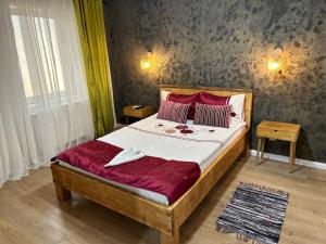 a bedroom with a large bed with red pillows at T4House in Sighişoara
