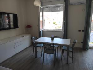 een eetkamer met een tafel en stoelen en een televisie bij Appartamento "A due passi" in Siderno Marina