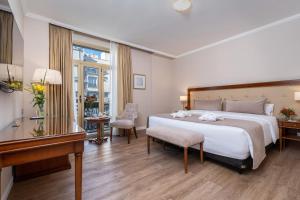 um quarto de hotel com uma cama grande e um piano em Hotel Intersur Recoleta em Buenos Aires