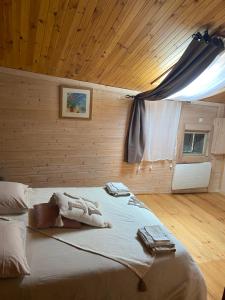a large bed in a room with a wooden ceiling at Gîte Le Cabanon in La Robine