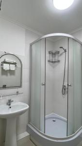 bagno bianco con doccia e lavandino di Алматы Транзит №1 a Turksib