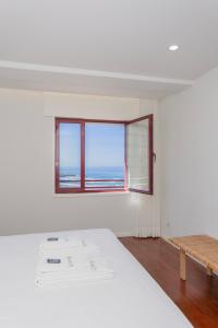 a white room with a bed and a window at Liiiving in Matosinhos - Seaside Balcony Apartment in Porto