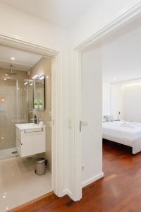 ein weißes Bad mit einem Waschbecken und einem Bett in der Unterkunft Liiiving in Matosinhos - Seaside Balcony Apartment in Porto