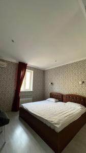 ein Schlafzimmer mit einem großen Bett in einem Zimmer in der Unterkunft Алматы Транзит №1 in Turksib