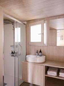 a bathroom with a sink and a glass shower at wecamp Cudillero in El Pito