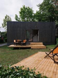 a small black building with a deck and a table at wecamp Cudillero in El Pito