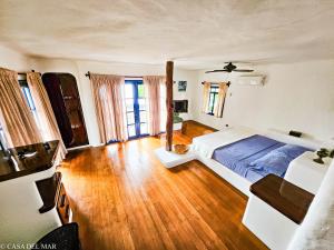 a bedroom with a bed and wooden floors and windows at Casa del Mar in Puerto Ayora