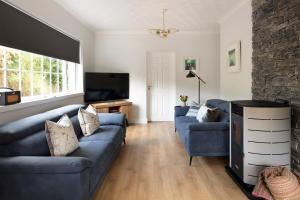 a living room with two blue couches and a television at Green Isle in Kenmare +7 photos