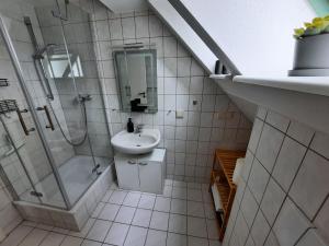 a white bathroom with a sink and a shower at Marktstübchen in Waren +6 photos