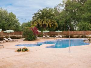 a large swimming pool with chairs and umbrellas at wecamp Cudillero in El Pito