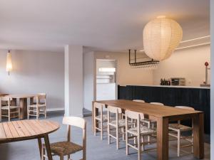 a dining room with a wooden table and chairs at wecamp Cudillero in El Pito