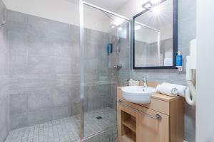 a bathroom with a sink and a shower at Appart'City Classic Reims Parc des Expositions in Reims