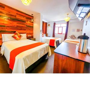 Habitación de hotel con 2 camas y pared de madera. en Ayacucho Plaza, en Ayacucho