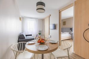 a dining room with a table and chairs and a living room at Appart'City Classic Reims Parc des Expositions in Reims