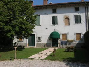 a large white house with a green awning at Bed & Breakfast Pegaso in Valeggio sul Mincio