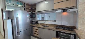 a kitchen with a refrigerator and a sink at Apartamento Vista para Mar in Guriri +10 photos