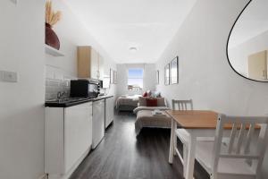 a living room with a kitchen and a dining room at Studio 6- Archway Station in London