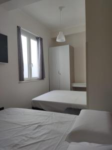 een slaapkamer met 2 bedden, een spiegel en een raam bij Appartamento "A due passi" in Siderno Marina