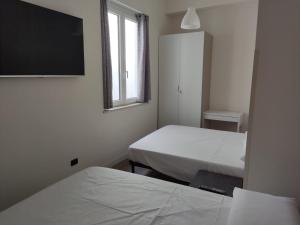 een kamer met 2 bedden en een flatscreen-tv bij Appartamento "A due passi" in Siderno Marina
