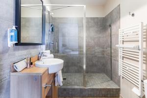 a bathroom with a sink and a shower at Appart'City Classic Reims Parc des Expositions in Reims