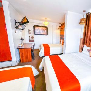 una camera d'albergo con 2 letti e una scrivania di Ayacucho Plaza ad Ayacucho