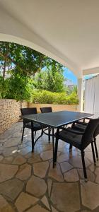 a ping pong table and chairs on a patio at Apartments Ivana in Sutivan