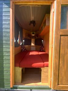 a small room with a red bed in a house at Pferdewagen Freya in Kröpelin