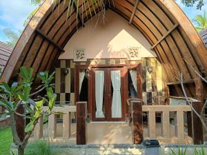 a small house with a large wooden door at Noby Gili Cottages in Gili Meno