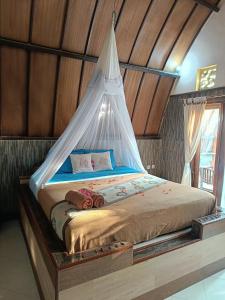 a bed with a canopy in a room at Noby Gili Cottages in Gili Meno