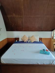 1 cama con manta azul y almohadas en Noby Gili Cottages en Gili Meno