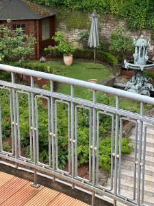 a fence in front of a garden with a fountain at Remedium Appartements in Vlotho