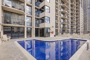 an apartment building with a swimming pool in front of a building at Exceptionally Located in Honolulu
