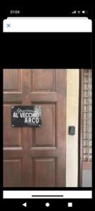 a wooden door with a sign on it at AL VECCHIO ARCO a Bari vecchia in Bari