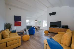 salon z żółtymi meblami i telewizorem z płaskim ekranem w obiekcie Casale Piazzetta w Rovinj