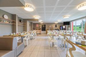 漢斯的住宿－Appart'City Classic Reims Parc des Expositions，用餐室配有桌子和白色椅子