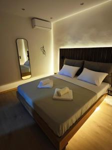 a bedroom with a large bed with towels on it at The Skeptic Home in Thessaloniki