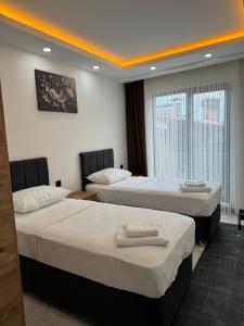 a hotel room with two beds and a window at MERKEZ Rezidans Suits in Trabzon