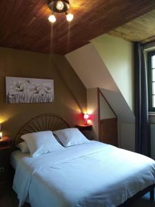 a bedroom with a large white bed in a room at Hôtel du Pont et Restaurant à Groléjac in Groléjac