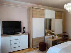 a bedroom with a tv on a white wall at Margó Vendégházak in Hajdúszoboszló