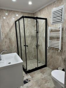 a bathroom with a shower and a toilet and a sink at MERKEZ Rezidans Suits in Trabzon +31 photos
