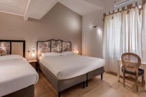 ピエトラサンタにあるB&b L' Orangerieのベッドルーム1室(ベッド2台、椅子付)