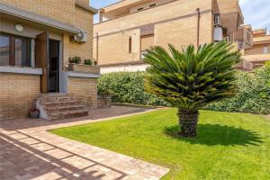a palm tree in front of a house at La Casetta-10 min Aeroporto e spiaggia in Fiumicino